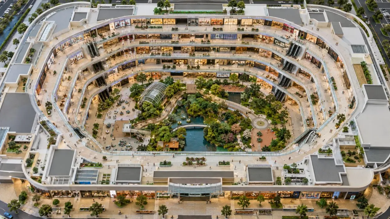 Un modello architettonico di un centro commerciale disposto come un anello di corridoi intorno a un parco centrale