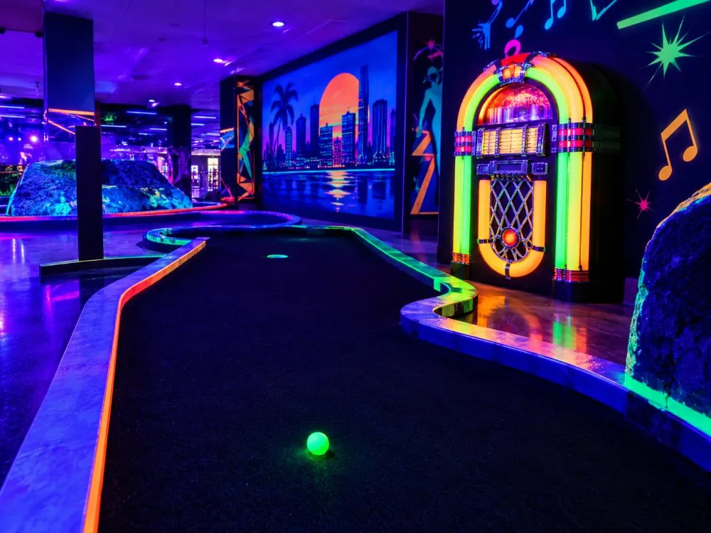 Ein leuchtendes Loch auf dem Schwarzlicht-Minigolfplatz