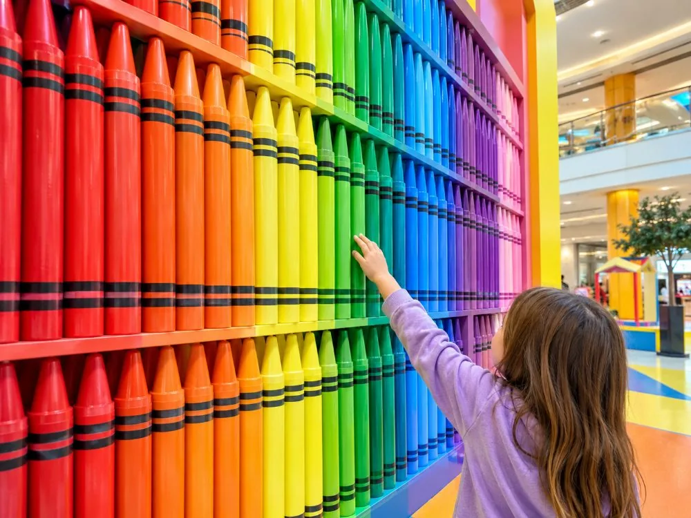 Eine Wand mit nach Farben sortierten Buntstiften im Crayola Experience