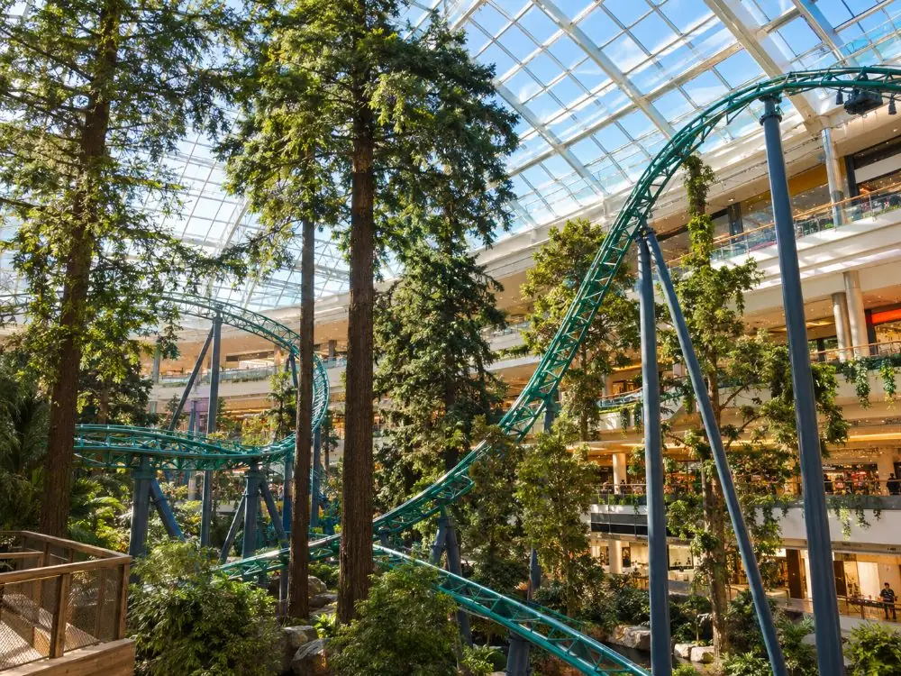Achterbahnschienen und Bäume unter dem Glasdach des Themenparks im Mall of America